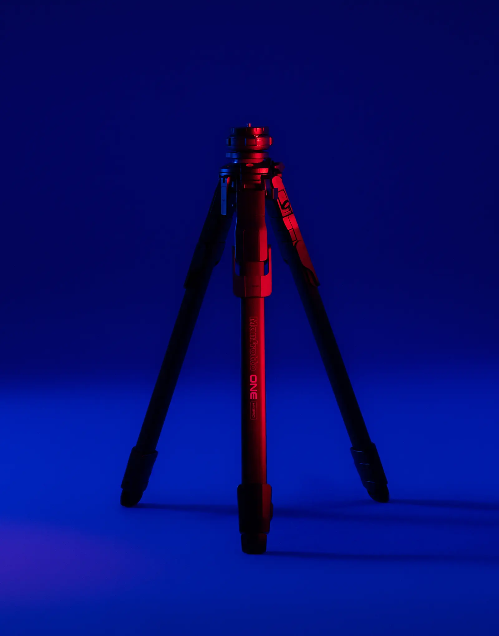 The ONE tripod by leading industrial design consultancy LAYER shown standing with its legs extended against a blue background.