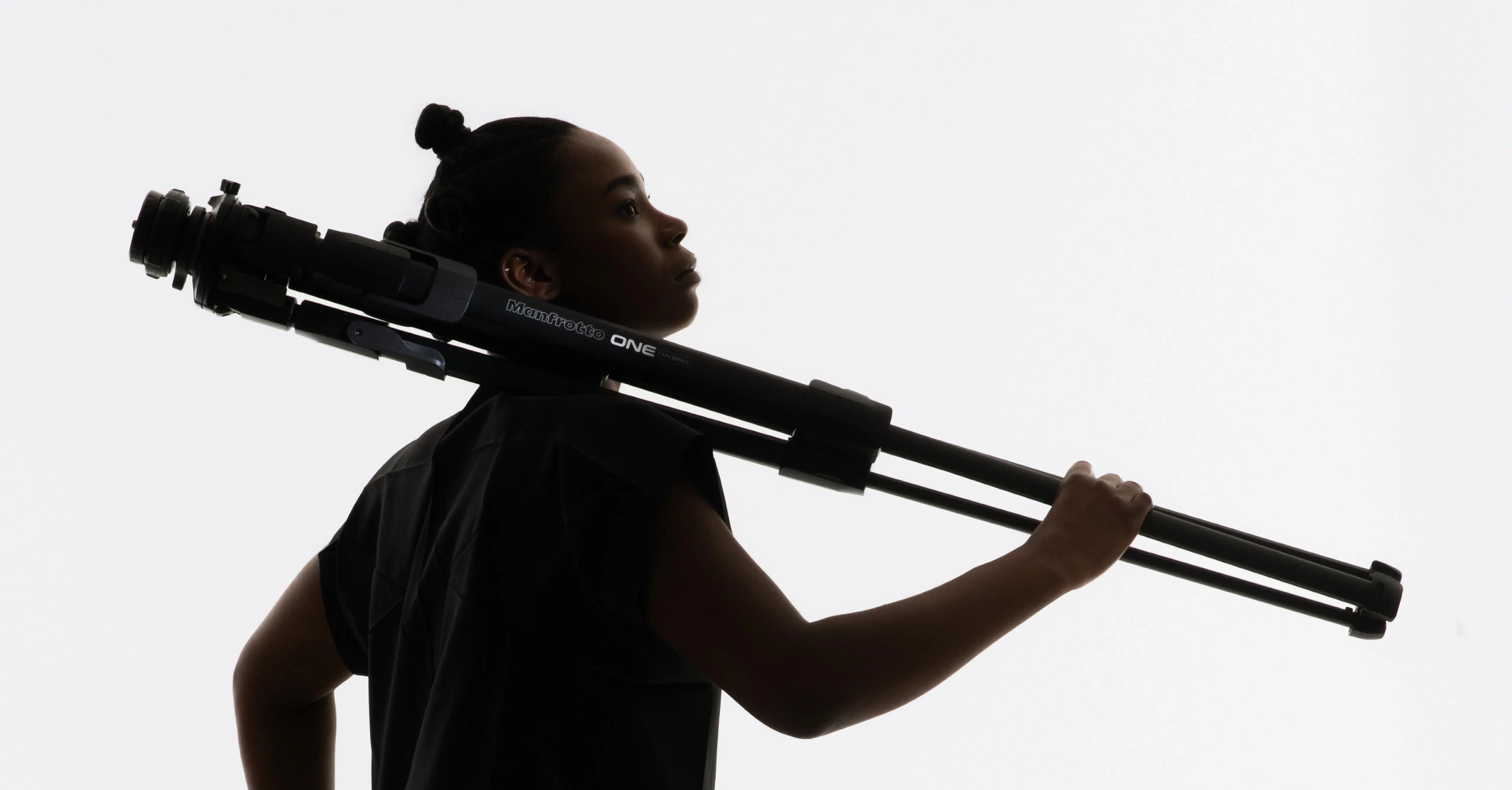 A person carrying the ONE tripod by leading industrial design consultancy LAYER over their shoulder against a white background.