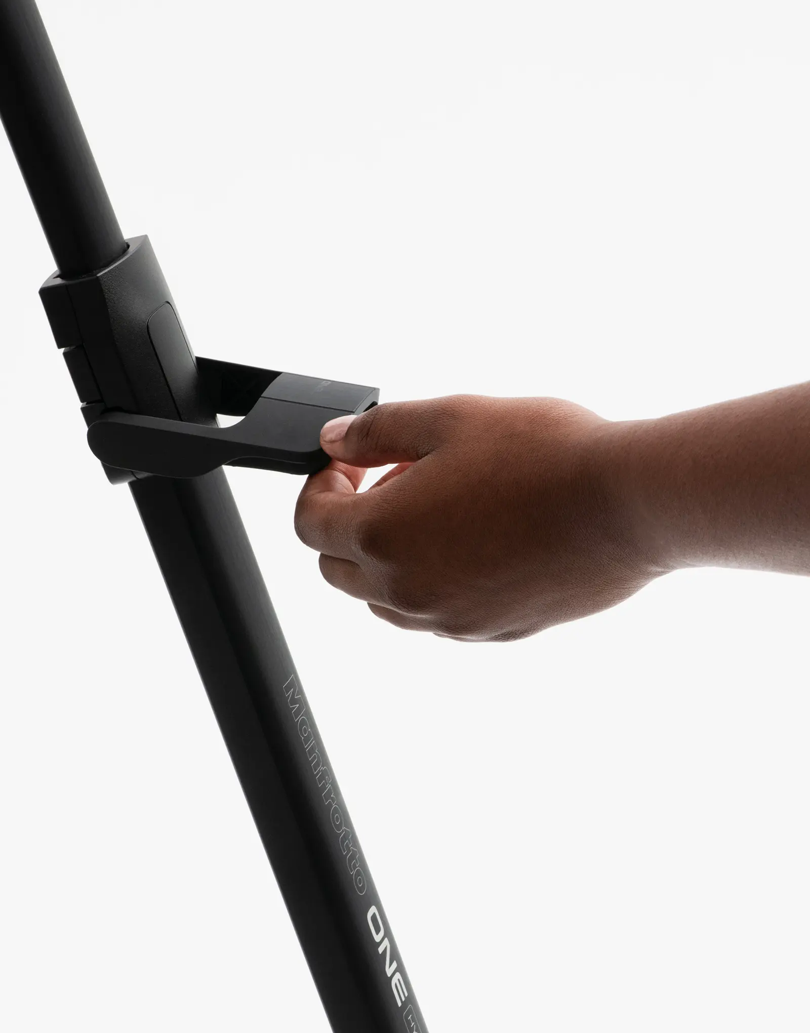 A hand adjusting the ONE tripod by leading industrial design consultancy LAYER using the leg-mounted control on a white background.