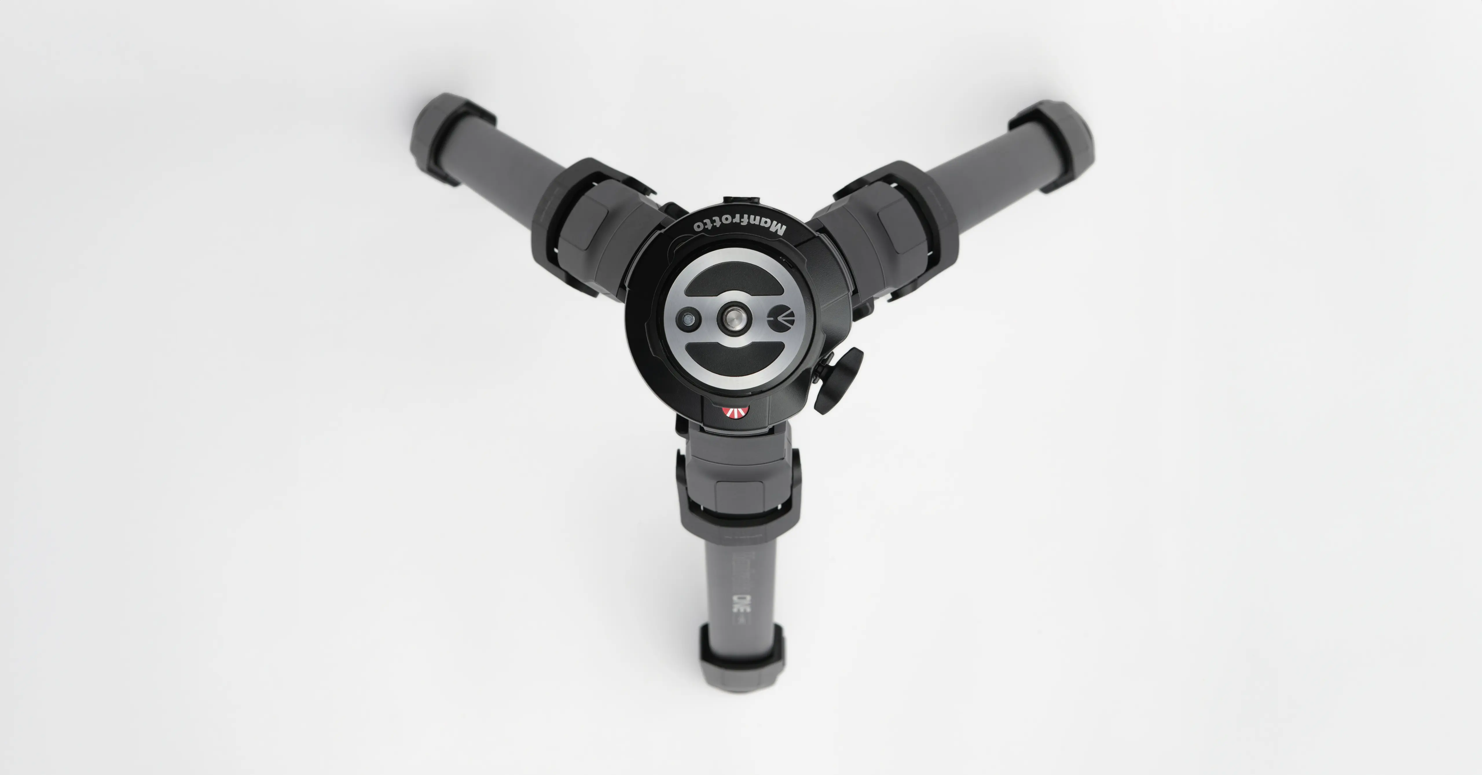 Top view of the ONE tripod head by leading industrial design consultancy LAYER with folded legs against a white background.