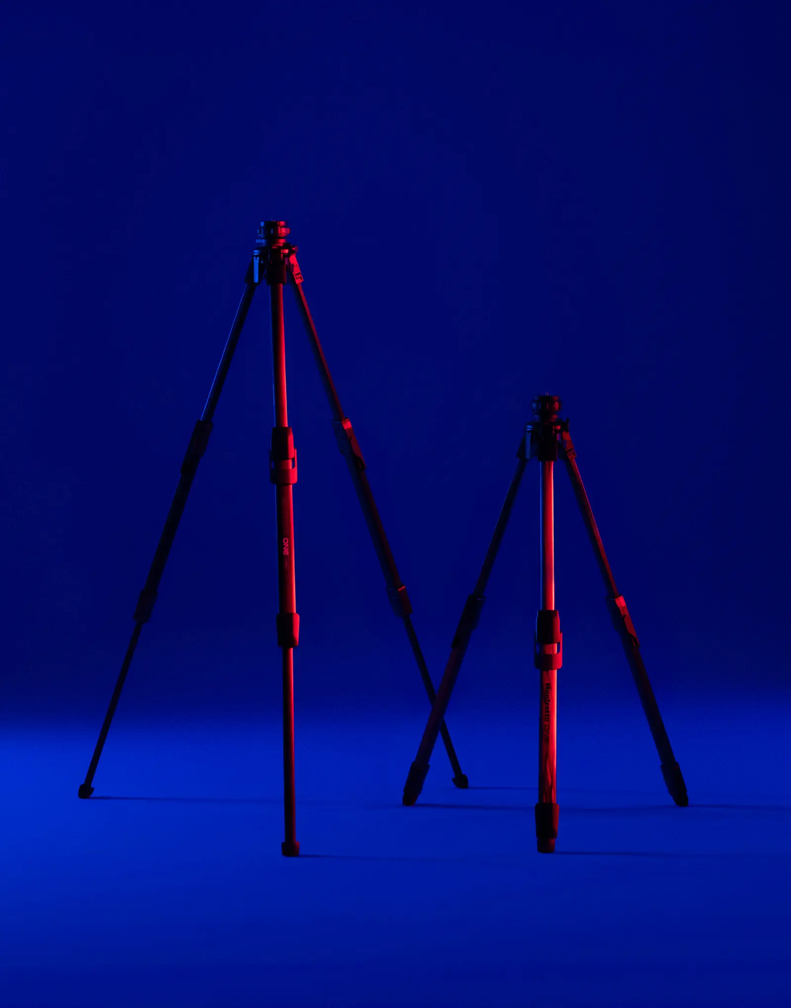 Two ONE tripods by leading industrial design consultancy LAYER shown at different heights against a blue background.